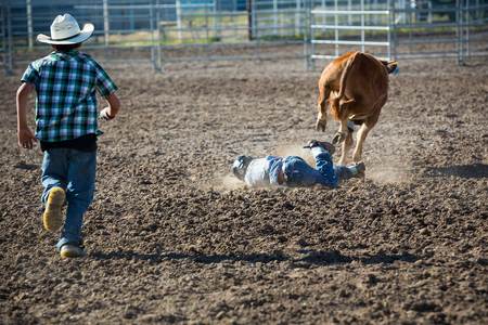 A young man gets thrown off the bull at the youth rodeo
